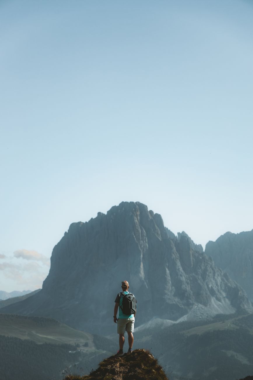 Wanderer observing expansive misty alpine valley